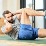 Bearded young man doing abs exercise at home