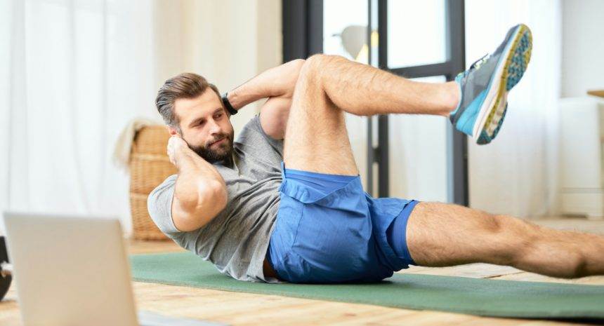 Bearded young man doing abs exercise at home