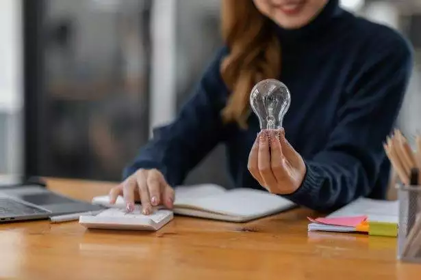 Business women hand holding light bulb, concept of new ideas with innovation and creativity.