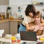 Happy young woman embracing her husband during communication in video chat