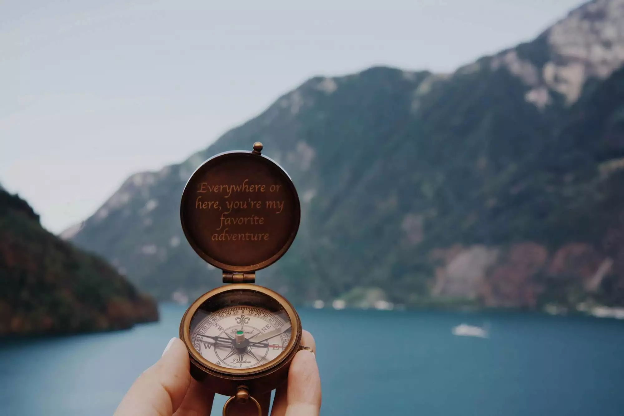 Open rustic compass pointing to the mountains for adventure travel