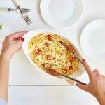 Woman hand's cooking trending viral baked tomatoes and feta with pasta